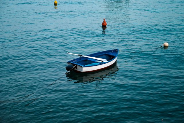 A small blue and white boat floating calmly on ocean water representing internal peace and overcoming overthinking